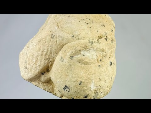 Egyptian limestone canopic jar lid, New Kingdom (1550–1070 BCE), carved in the likeness of Imsety, human-headed son of Horus, with aged patina and mounted display base.