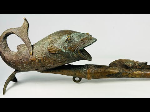 Video showing a Central African bronze pipe cast in fish form, featuring verdigris patina and sculptural detailing, Cameroon, early–mid 20th century.