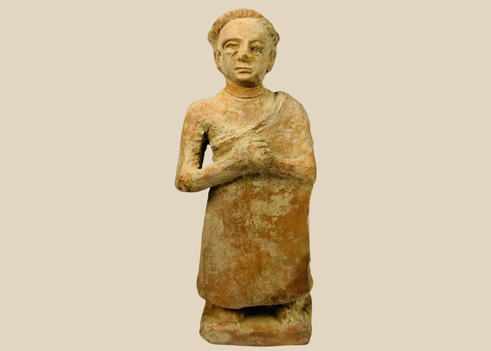 Primitive terracotta standing male figure with clasped hands