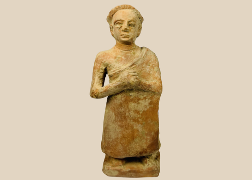 Primitive terracotta standing male figure with clasped hands