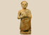 Primitive terracotta standing male figure with clasped hands