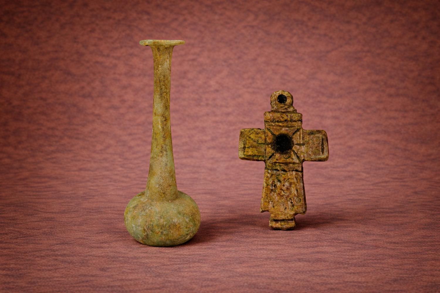 Ancient Greek artifacts including a long-neck glass vessel and bronze cross pendant displayed by Relic & Rarity