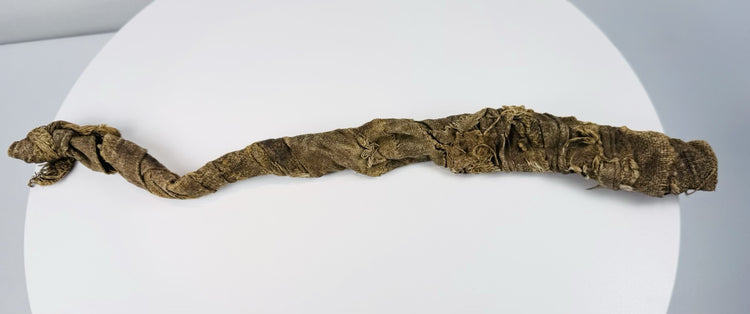 Ancient Egyptian animal mummy with curved crocodile form and extensive surviving linen wrapping
