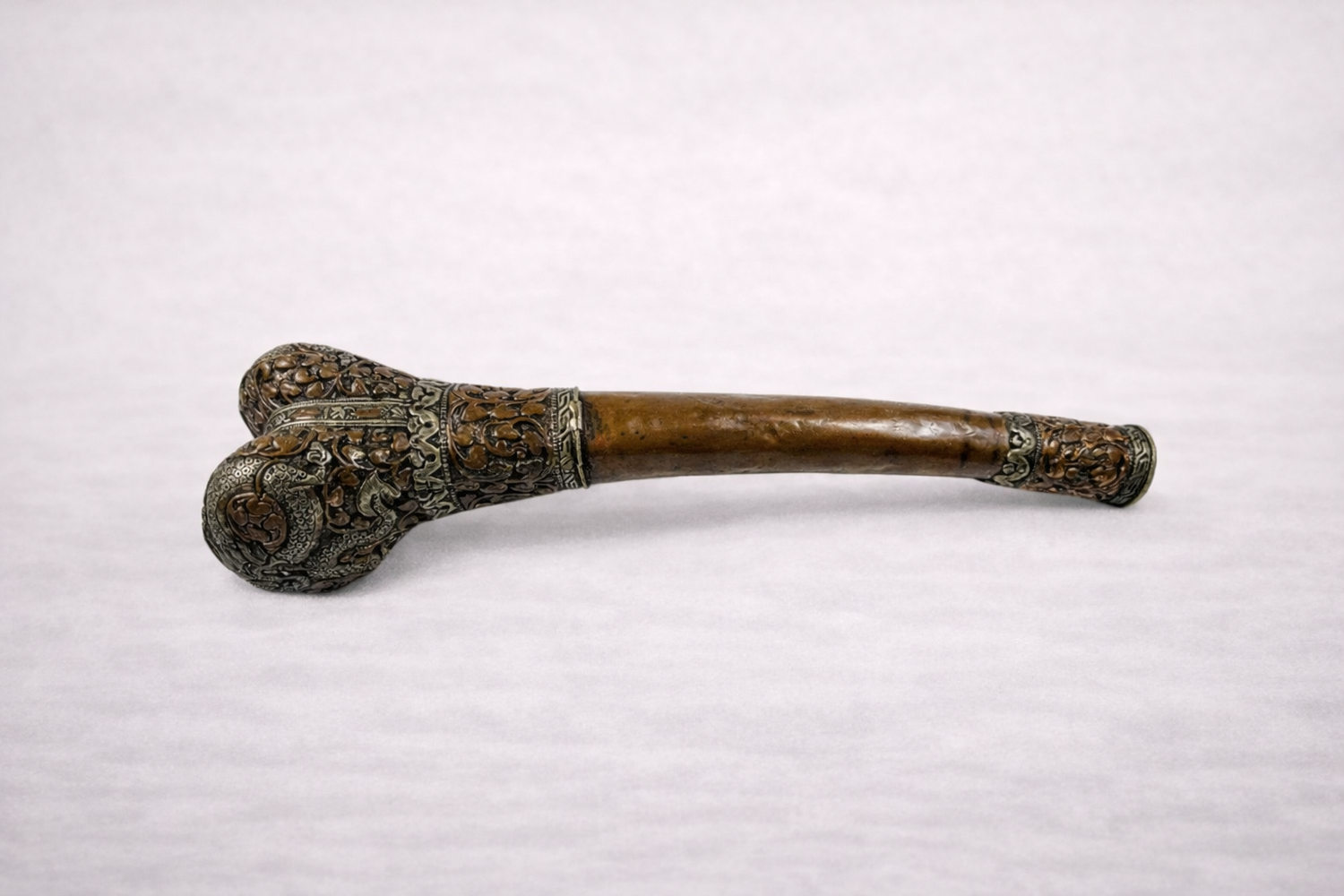 Antique Tibetan Kangling ritual trumpet crafted from human bone with ornate metal mounts used in Tibetan Buddhist ceremonies